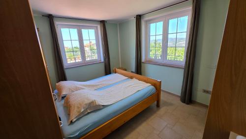 a small bedroom with a bed and two windows at New Big Butterfly Rooms - Free parking in Koper