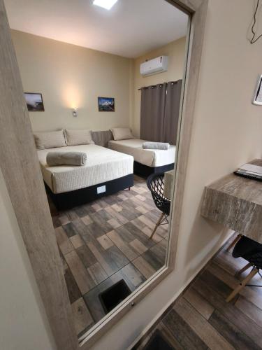 a view of a room with two beds and a mirror at Hotel Boutique Porá Iguazú in Puerto Iguazú