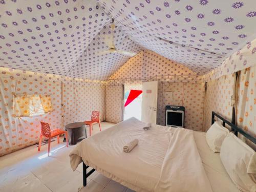 a bedroom with a bed in a room with polka dots at Big Brand Desert Camp in Jaisalmer