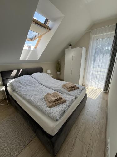 a bedroom with a bed with two towels on it at Apartamenty Kaszuba in Chmielno