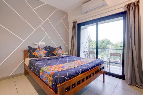 a bedroom with a bed and a large window at FabHotel Casa Mandrem in Mandrem