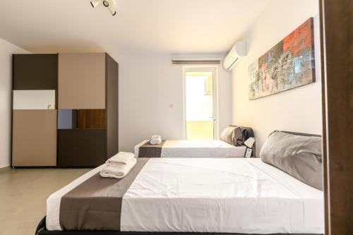 a bedroom with two beds and a cabinet at F41 Private room ensuite shared flat in Il-Gżira