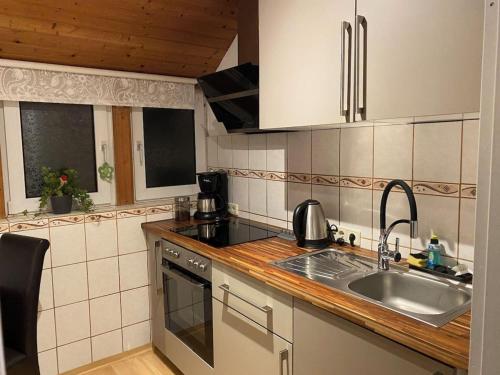 a kitchen with a sink and a counter top at Ferienwohnung Sonnenschein mit Balkon in Lage