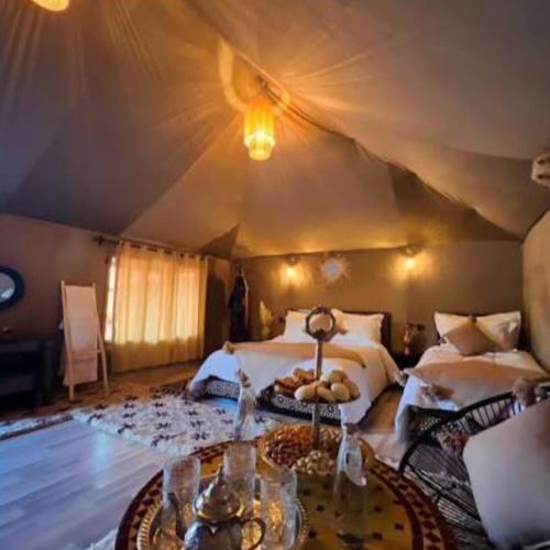 a bedroom with two beds in a tent at Best-Merzouga traditional camps in Merzouga
