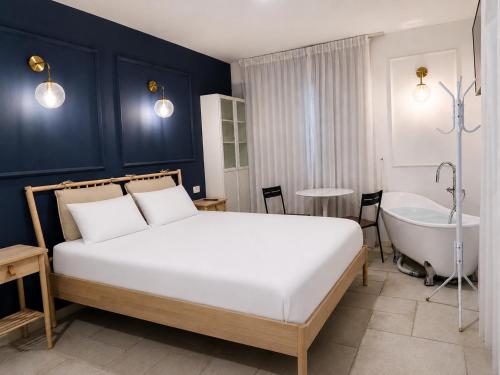 a bedroom with a bed and a bathtub and a bath tub at זוהר על הים - ווילה ו-3 חדרי סטודיו מהממים עם בריכה בנווה זוהר in Neve Zohar