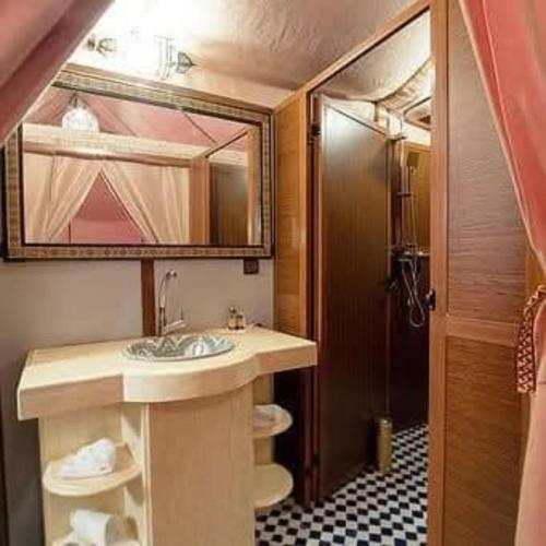 a bathroom with a sink and a mirror at Best-Merzouga traditional camps in Merzouga