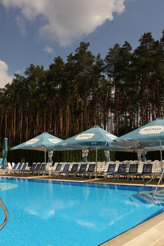 a swimming pool with chairs and umbrellas at Kryve Ozero in Novoyavorivsk