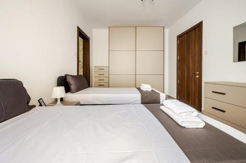 a bedroom with two beds and a dresser at GZR F51 Bedroom in Penthouse in Il-Gżira