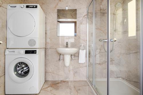 a bathroom with a washing machine and a sink at GZR F51 Bedroom in Penthouse in Il-Gżira