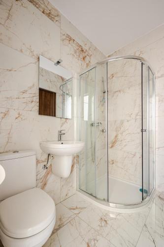 a bathroom with a shower and a toilet and a sink at GZIRA F52 Bedroom in pethouse in Il-Gżira