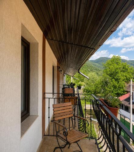 a porch with a wooden bench on a balcony at Pensiunea Mirela Bears Cave in Chişcău