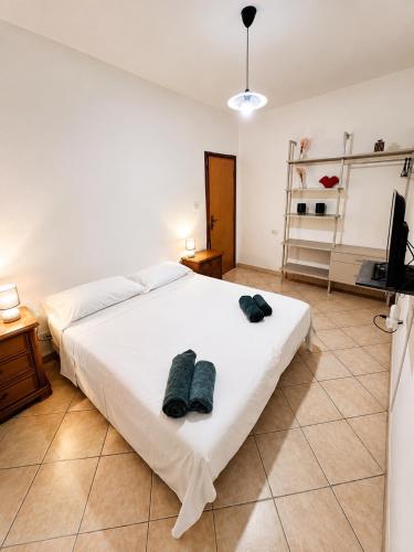 a bedroom with a white bed with two towels on it at Mordano Apartment - ampio appartamento SELF CHECK-IN vicino a Imola in Mordano