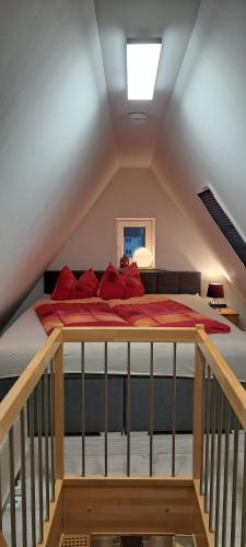 a bed with red pillows in a attic at Ferienwohnung HEIDI in Donauwörth