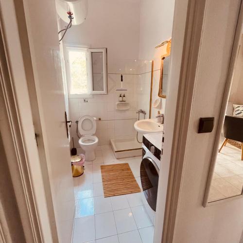 a white bathroom with a toilet and a sink at Casa Bellina ,Potamos Private Garden & Free Parking in Evropoúloi
