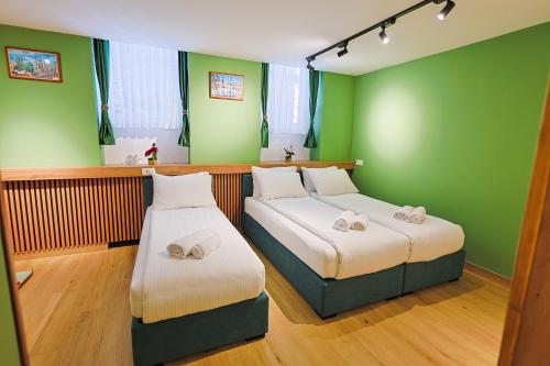 two beds in a room with green walls at FourMountains-Jahorina in Sarajevo