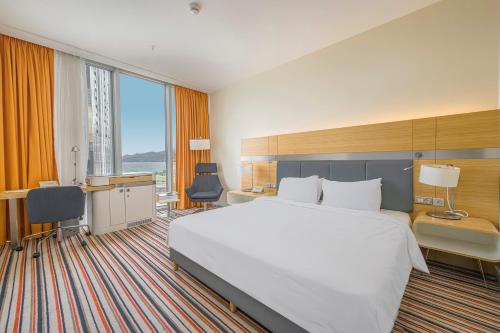 a hotel room with a large bed and a desk at Radisson Blu Hotel Batumi in Batumi