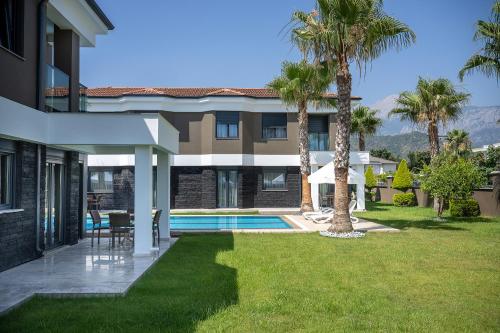 a house with a swimming pool and palm trees at L'Oceanica Beach Resort in Kemer