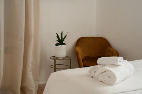 a room with a bed with towels and a chair at Il Grottino Relais & Spa in Gualdo Cattaneo
