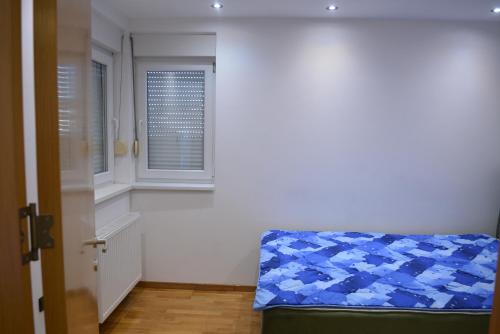 a room with a blue couch and a window at Rio Apartmani Ub 3 in Ub
