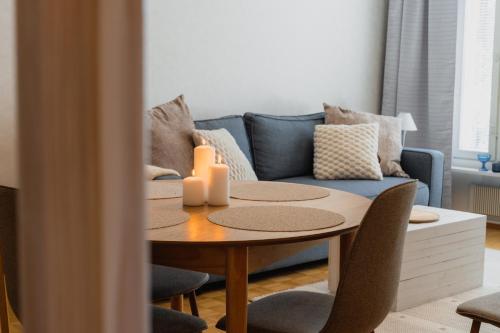 a living room with a table and a blue couch at Nordic Nova II by Elys Collection in Rovaniemi