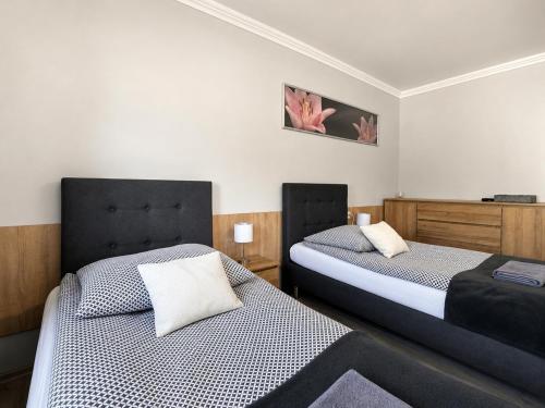 two beds in a small room with two bedsvisor at Apartamenty Adabet in Kępno