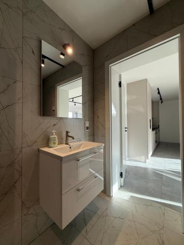 a bathroom with a sink and a mirror and a shower at Apartamenty u Rybaka in Stężyca