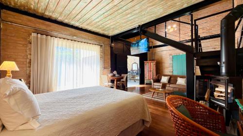 a bedroom with a large bed and a staircase at LA PIANTA - Seu refúgio na Vila de Monte Verde in Monte Verde