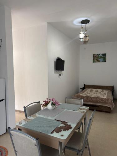 a dining room with a table and chairs and a bed at Guest House GT in Oni