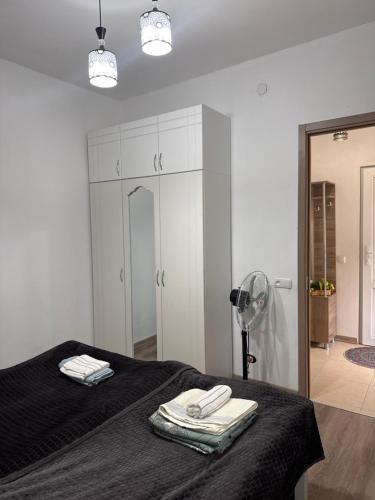 a bedroom with a bed with towels and a fan at Guest House GT in Oni