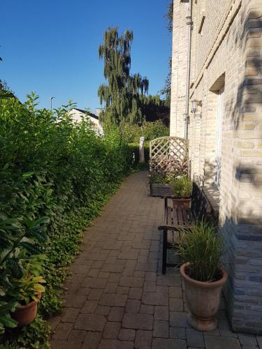a brick walkway with two benches next to a building at Haus Sonne _ Meer in Sierksdorf