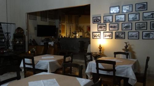 a restaurant with tables and chairs and pictures on the wall at Pousada Cheiro da Terra in Cunha