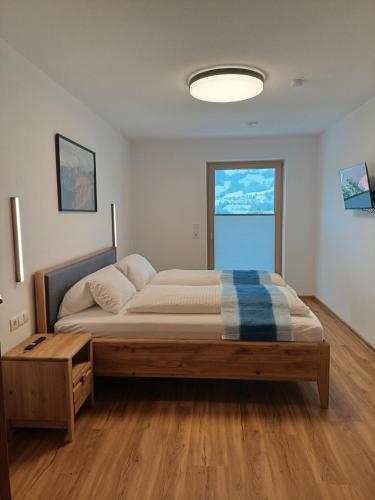 a bedroom with a bed and a large window at EK-Living in Fügen