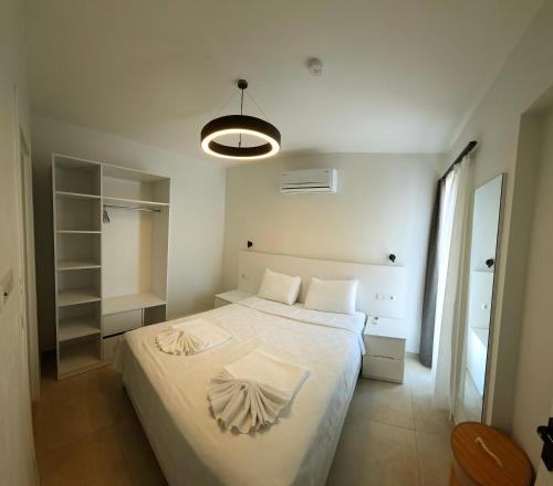 a bedroom with a large white bed and a lamp at Aera Villas - Kaş in Kaş