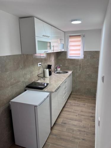 a kitchen with white cabinets and a counter top at Smeštaj Stamenić in Bajina Bašta