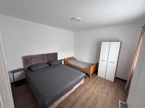 a small bedroom with a bed and a cabinet at Smeštaj Stamenić in Bajina Bašta