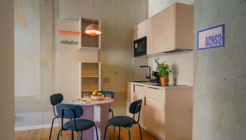 a small kitchen with a small table and chairs at Homaris K48 Studios in Berlin