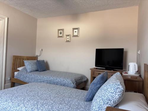 a bedroom with two beds and a flat screen tv at No 3 in Penrith
