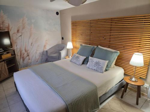 a bedroom with a large bed and a chair at Gite Le Clos de Sée in Chérencé-le-Roussel