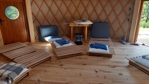 a room with three beds and a table in a yurt at La Yourte Un Autre Monde in Le Hohwald