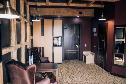 a living room with two chairs and a door at Megapolis Hotel Shymkent in Shymkent