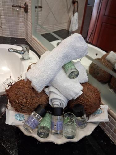a bathroom sink with a pile of towels and cleaning products at Miranda's Apartments in Koskinou