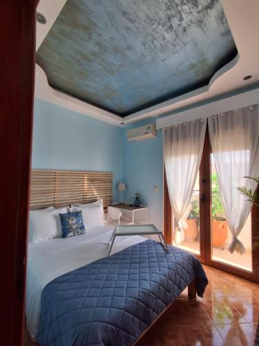 a bedroom with a bed with a painting on the ceiling at Miranda's Apartments in Koskinou