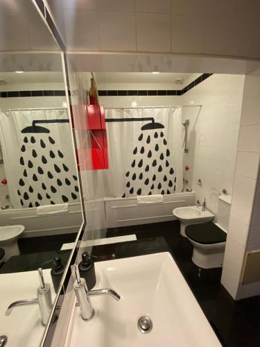 a bathroom with a sink and a toilet and a mirror at Casa Ferreira in Beja