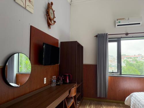 a bedroom with a mirror and a bed and a tv at Khách sạn Trọng Thiêm 1 in Ấp Thiện Lập