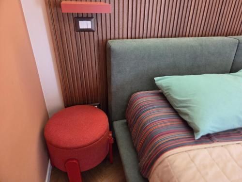 a small room with a bed and a red stool at La dimora del figulo in Rutigliano
