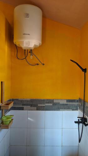 a light on a yellow wall in a bathroom at Tsanta lodge in Talata-maty