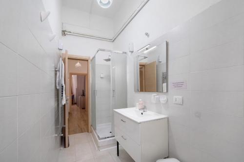 a white bathroom with a sink and a mirror at Home Joséphine - Caserta in Caserta