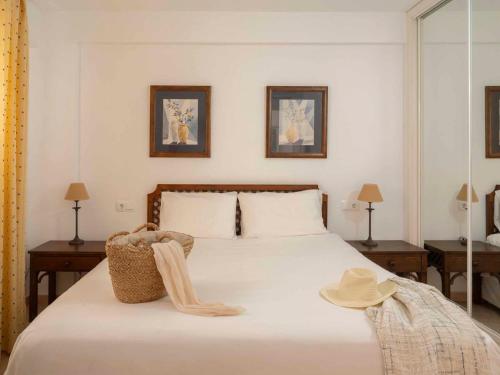 a bedroom with a bed with a hat on it at Ona Garden Lago in Port d'Alcudia