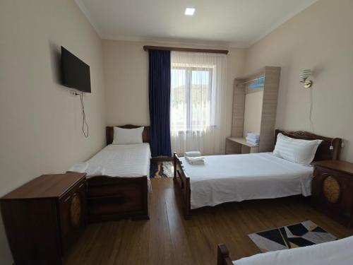 a hotel room with two beds and a television at NUR TOON in Areni