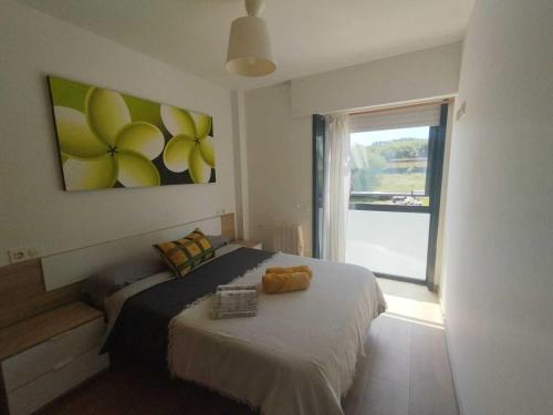 a bedroom with a bed with a painting on the wall at Confortable piso en Ares in Ares